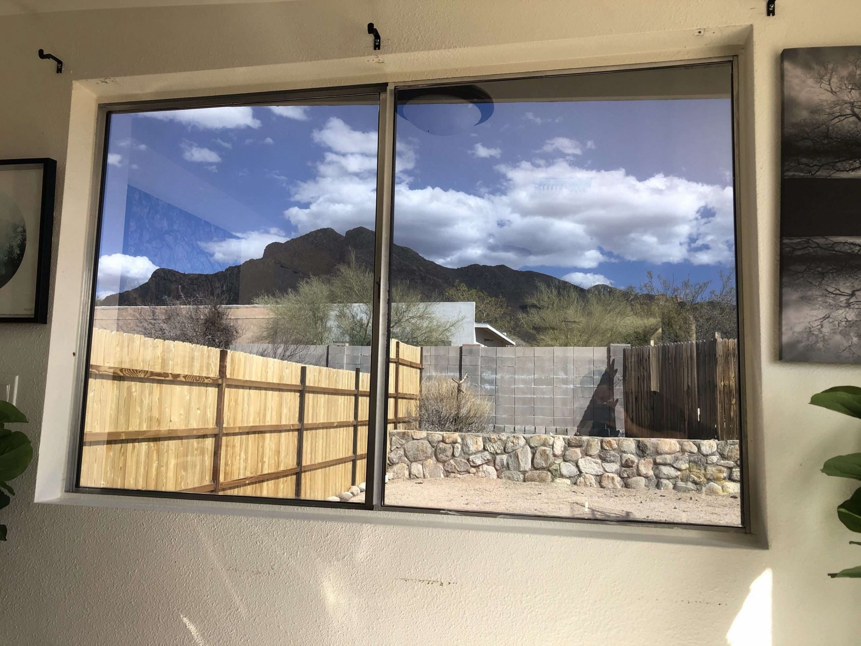 A living-room window framing the Catalina foothills under a bright cloudy sky